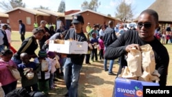 Mandelin unuk Zondva Mandela deli pakete hrane siromašnima u okviru proslave rodjendana njegovog dede. 18, juli, 2013.