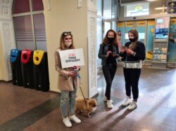 A supporter of Raman Pratasevich holding a placard reading 'I am/we are Roman Protasevich' waits for the arrival of a Ryanair flight after it was diverted to Belarus, at Vilnius Airport in Vilnius, May 23, 2021.