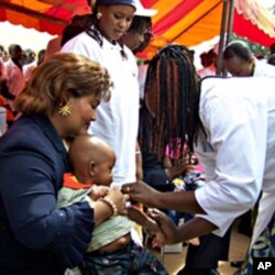La première dame du Burkina Faso, Chantal Compaoré, aidant à vacciner un enfant contre la méningite en décembre 2010