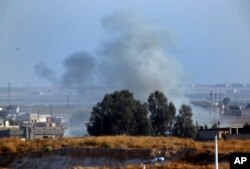In this photo taken from the Turkish side of the border between Turkey and Syria, in Akcakale, Sanliurfa province, southeastern Turkey, smoke billows from a fire inside Syria during bombardment by Turkish forces Wednesday, Oct. 9, 2019.
