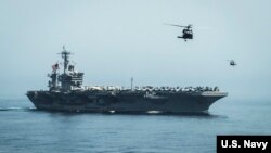 Helicopters fly from the aircraft carrier USS Theodore Roosevelt (CVN 71) during a vertical replenishment with the aircraft carrier USS Carl Vinson (CVN 70), April 13, 2015.