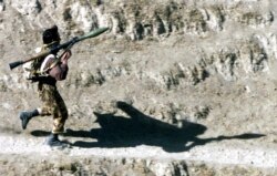 FILE - A fighter armed with a Soviet-made RPG-7 rocket launcher runs towards his position in Northern Afghanistan, Oct. 14, 2001. A U.S. company is selling a redesigned and updated version of the Soviet RPG-7 anti-tank weapon to Ukraine.