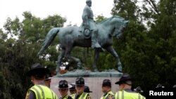 កងកម្លាំង​សន្តិសុខ​របស់​រដ្ឋVirginia ឈរ​នៅ​ពី​ក្រោម​រូប​សំណាក​របស់​លោក Robert E. Lee មុន​ពេល​មាន​ការ​ប្រមូល​ផ្តុំ​របស់​អ្នក​ជាតិ​និយម​ស្បែក​ស​នៅ​ក្នុង​ក្រុង Charlottesville រដ្ឋ Virginia សហរដ្ឋ​អាមេរិក កាលពី​ថ្ងៃទី១២ ខែសីហា ឆ្នាំ២០១៧។