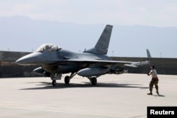A U.S. Air Force crew chief signals the pilot of an F-16 Flying Falcon as it taxis for a mission at Bagram air field in Afghanistan Aug. 11, 2016.