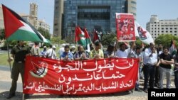 Para pemuda Persatuan Demokrasi Palestina membawa spanduk dan bendera Palestina dan berunjuk rasa di depan markas besar PBB di Beirut menandai peringatan 64 tahun 'Nakba', hijrahnya warga Palestina sejak berdirinya Israel tahun 1948 (15/5).
