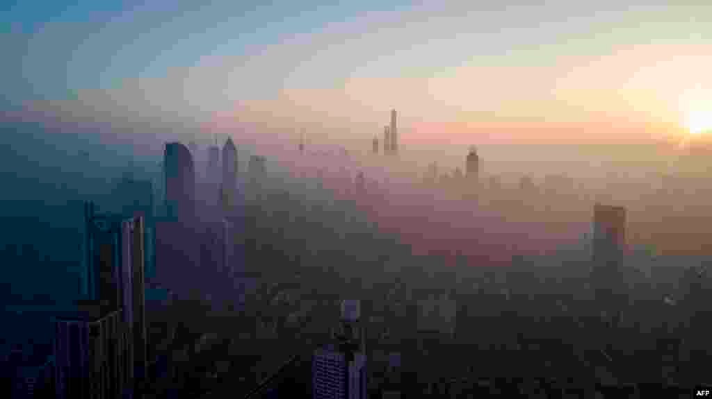 2018年2月23日，上海空气污染较重，太阳升起，照耀高楼大厦。