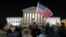 FILE - a protester waves an American flag in front of the Supreme Court during a protest about President Donald Trump's recent executive orders in Washington. 
