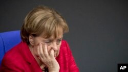 FILE - Chancellor Angela Merkel attends a plenary session of German parliament Bundestag in Berlin, Nov. 21, 2017. Merkel is now considering a grand coalition with Social Democrats.