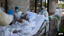 Petugas medis membawa pasien Covid-19 keluar dari Unit Gawat Darurat (foto: ilustrasi). 