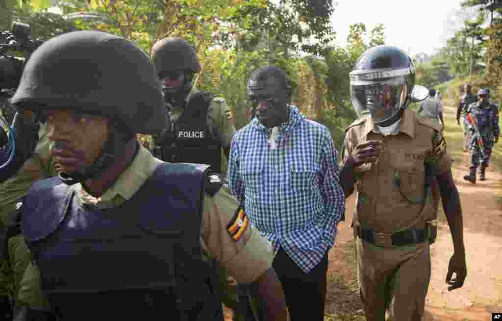 FILE - Uganda&#39;s main opposition leader Kizza Besigye, center, is arrested by police and thrown into the back of a blacked-out police van which whisked him away and was later seen at a rural police station, outside his home in Kasangati, Uganda, Feb. 22, 2