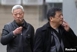 FILE - Smokers are seen on a street in Shanghai, China, March 22, 2012.
