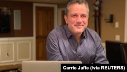 Jonathan Jaffe poses for a photograph in his "man cave" at his Scotch Plains, New Jersey, home, where he produces The Jaffe Briefing. (Carrie Jaffe/Handout via REUTERS.)
