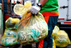 Seorang pekerja membawa kantong sampah medis di Jakarta. (Foto: REUTERS/Ajeng Dinar Ulfiana)