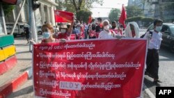 អ្នកគាំទ្រគណបក្ស​សម្ព័ន្ធ​ជាតិ​ដើម្បី​លទ្ធិ​ប្រជាធិបតេយ្យ (NLD) កាន់បដាក្នុងអំឡុងក្បួនដង្ហែមួយដើម្បីបង្ហាញការគាំទ្រដល់ប្រធានាធិបតីមីយ៉ាន់ម៉ា និងគណៈកម្មការរៀបចំការបោះឆ្នោត នៅក្រុងរ៉ង់ហ្គូន ប្រទេសមីយ៉ាន់ម៉ា ថ្ងៃទី២៤ ខែមករា ឆ្នាំ២០២១។