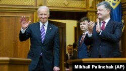 FILE - Ukrainian President Petro Poroshenko, right, applauds to U.S. Vice President Joe Biden, left, after he addressed the Ukraine Parliament in Kyiv, Ukraine, Dec. 8, 2015. 
