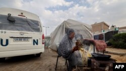 27일 가자지구 남부에 주차된 'UN' 표시 차량 앞에서 팔레스타인 피란민이 취사하고 있다. 