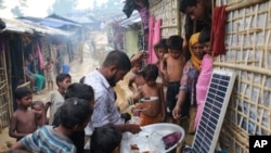 អ្នក​លក់​កំពុង​លក់​ចំណី​ទៅកាន់​កុមារនៅ​ជំរំ​ជន​ភៀស​ខ្លួន Kutupalong ប្រទេស​បង់ក្លាដែស​កាលពី​ថ្ងៃទី ០៣ តុលា ២០១៧។