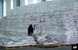 FILE - A worker walks next to a pile of sacks of food earmarked for the Tigray and Afar regions in a warehouse of the World Food Programme (WFP) in Semera, the regional capital for the Afar region, in Semera, Ethiopia, Feb. 21, 2022.