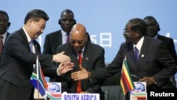 FILE - China's President Xi Jinping, left, shakes hands with Zimbabwe's President Robert Mugabe, right, while South Africa's President Jacob Zuma looks on during a Forum on China-Africa Cooperation in Sandton, Johannesburg, Dec. 4, 2015.