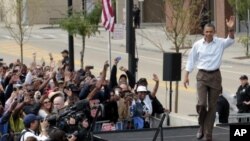 President Barack Obama waves as he is introduced on stage during a Labor Day event at Detroit's Renaissance Center, headquarters of General Motors, in Detroit, Michigan, September 5, 2011.