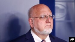 Dr. Robert Redfield, director of the Centers for Disease Control and Prevention, listens as President Donald Trump speaks during a coronavirus task force briefing at the White House, March 22, 2020, in Washington.