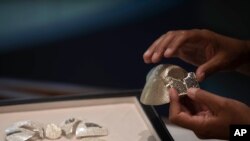 Isaac Levy, owner of Israeli jewelry company Yvel holds parts of a mask in Motza near Jerusalem, Aug. 9, 2020. 