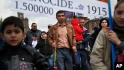 FILE - Armenians carry a placard with a sign reading "1915" and "1500000", the year and alleged numbers of victims of mass killings of Armenians by Ottoman Turks on a street in Yerevan, Armenia, April 24, 2015. Turkey denies the killings were genocide.