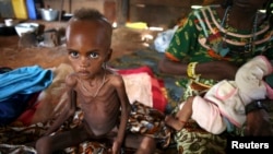 A sick internally displaced Muslim girl sits next to her mother in a house in the town of Boda, April 15, 2014.