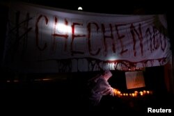 Activists from the group Chok3 paint a banner with their own blood during a protest discrimination and violence against the gay community in Chechnya and other regions of Russia, outside the Russian embassy in Mexico City, Mexico, April 20, 2017.