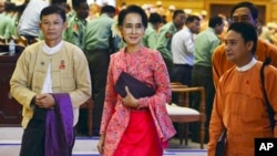 Pemimpin oposisi Myanmar Aung San Suu Kyi, tengah, berjalan bersama anggota DPR lainnya dari partai Liga Nasional untuk Demokrasi setelah rapat pada 1 Februari 2016 di Naypyitaw, Myanmar. 