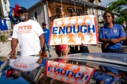 FILE - Community members and police attend a vigil beside a makeshift memorial at the scene where Justin Wallace, 10, was shot and killed the previous Saturday night in the Rockaway section of the Queens borough of New York, June 9, 2021.