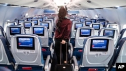 A passenger wears personal protective equipment on a Delta Airlines flight after landing at Minneapolis−Saint Paul International Airport, Thursday, May 28, 2020, in Minneapolis. (AP Photo/John Minchillo)