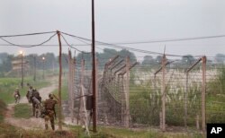 Indian Border Security Force soldiers walk near the India-Pakistan international border area at Gakhrial boder post in Akhnoor sector, about 48 kilometers (30 miles) from Jammu, India, Oct. 1, 2016.