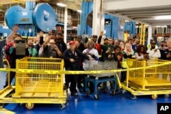 FILE - Employees of Carrier watch as President-elect Donald Trump and Vice President-elect Mike Pence take a tour in Indianapolis, Indiana, Dec. 1, 2016.