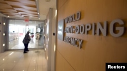 A woman walks into the head office for the World Anti-Doping Agency (WADA) in Montreal, Nov. 9, 2015. The agency says Russian hackers compromised confidential athlete data relating to the Rio Olympics.