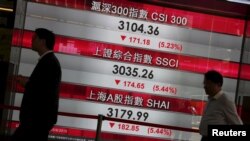 Warga melewati papan yang memperlihatkan kejatuhan indeks-indeks saham China, di Hong Kong (25/8). (Reuters/Bobby Yip)
