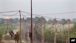 FILE - Indian Border Security Force soldiers walk near the India-Pakistan international border area at Gakhrial boder post in Akhnoor sector, about 48 kilometers (30 miles) from Jammu, India, Oct. 1, 2016.