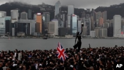 រូបភាព​ឯកសារ៖ ក្រុម​បាតុករ​កាន់​ទង់ជាតិ​អង់គ្លេស​ដើរ​ក្បួន​នៅ​ក្បែរ​កំពង់ផែ​ក្នុង​ក្រុង​ហុងកុង កាលពី​ថ្ងៃទី៧ ខែកក្កដា ឆ្នាំ២០១៩។