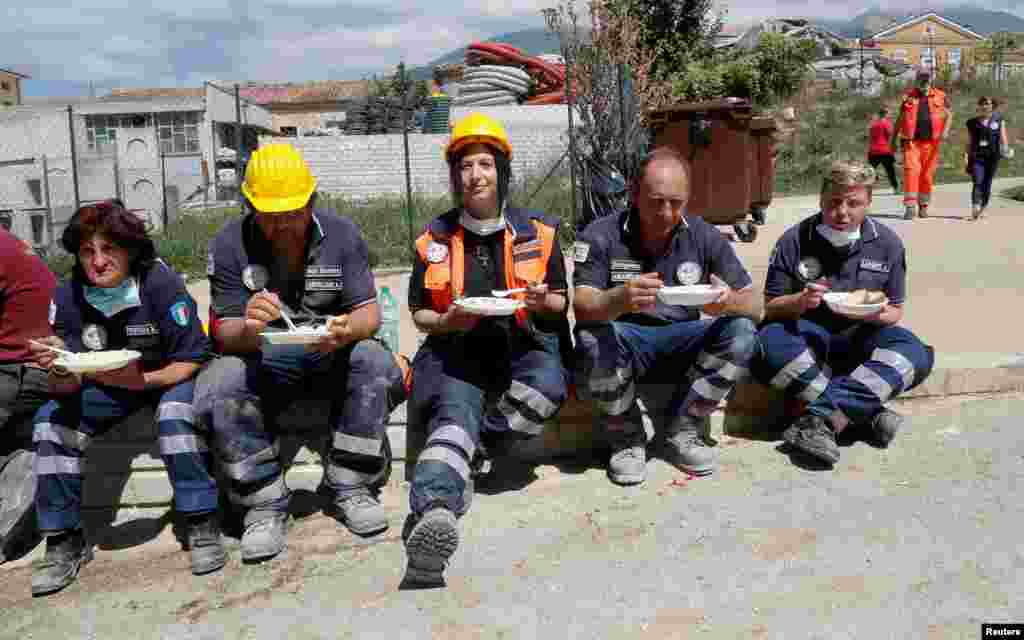 Rescuers rest and have food following an earthquake in Amatrice, central Italy, Aug. 25, 2016.