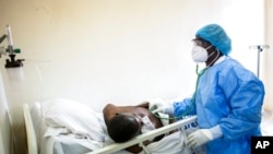 FILE - A doctor uses a stethoscope to listen to the breathing of a patient confirmed to have COVID-19 at the Fann university hospital in Dakar, Senegal, May 13, 2020.