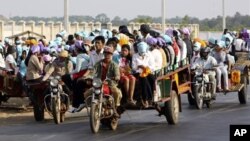 Cambodian garment factory workers travel together in motor carts to get home from work at the Sala Lek Pram village, Kampong Chhnang province.