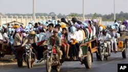 កម្មករ​កាត់ដេរ​ធ្វើ​ដំណើរ​រួម​គ្នា លើ​រ៉ឺម៉ក​មូតូ​ ពី​ផ្ទះ​រោងចក្រ​ទៅ​ផ្ទះ​វិញ។