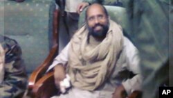 Saif al-Islam Gadhafi sitting with his captors in Obari airport November 19, 2011. Saif al-Islam has been captured in Libya's southern desert with a handful of supporters.