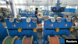 中国浙江省湖州市的一个通讯设备厂光纤生产线上的工人在工作。（2020年5月15日）路透社照片