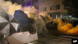 Tear gas fills the air during protests, Sept. 18, 2020, in Portland, Ore. The protests, which began over the killing of George Floyd, often result frequent clashes between protesters and law enforcement. 