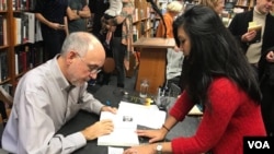 Author John Burgess with VOA Khmer reporter Manilene Ek at the book signing of his latest work, "The Stairway Guide's Daughter," at Politics and Prose bookstore, Washington DC, November 19, 2017. (Photo: VOA Khmer)