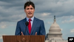 Canadian Prime Minister Justin Trudeau speaks to reporters from the roof of the Canadian Embassy in Washington after a day of meetings on a replacement for the North American Free Trade Agreement, June 20, 2019.