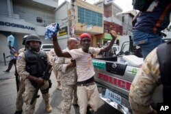 A demonstrator is detained after clashes with national police during a protest against government tax hikes in Port-au-Prince, Haiti, Oct. 5, 2017.