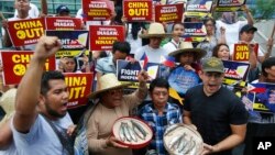 Protesters shout slogans while displaying small catch during a rally at the Chinese Consulate in the financial district of Makati city to protest alleged continued seizure of catches of Filipino fishermen at a disputed shoal in the South China Sea.