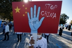 A protester from the Uighur community living in Turkey, holds an anti-China placard during a protest in Istanbul, Oct. 1, 2020, against what they allege is oppression by the Chinese government to Muslim Uighurs in far-western Xinjiang.